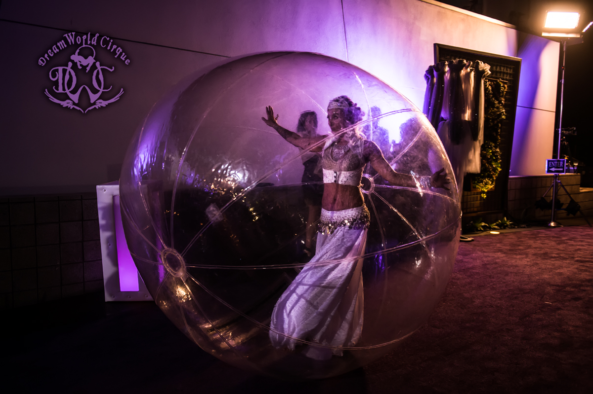 A beautiful ethereal dancer in a large clear bubble sphere greets guests as they arrive at the event