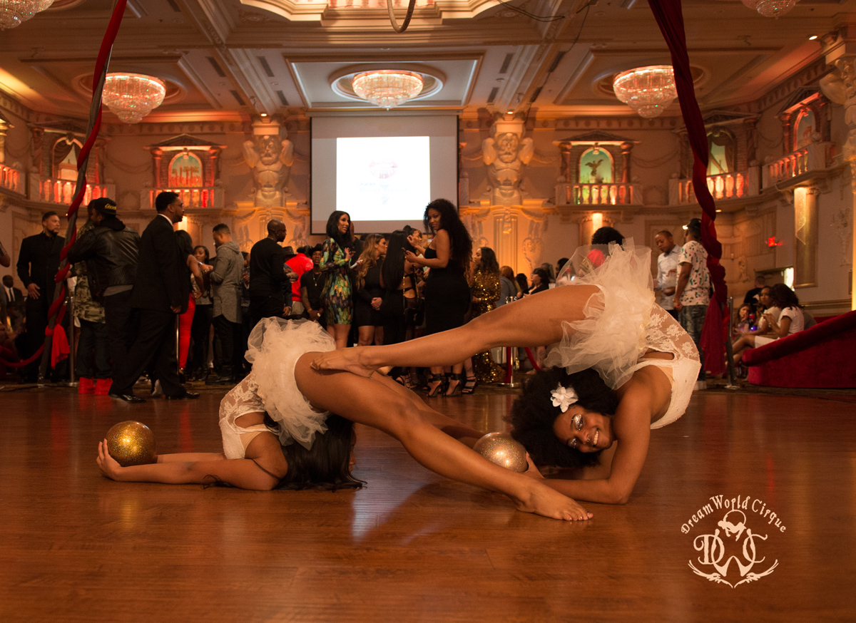 two contortionists with sparkly gold balls perform incredible balances and poses using each other's bodies to create beautiful shapes