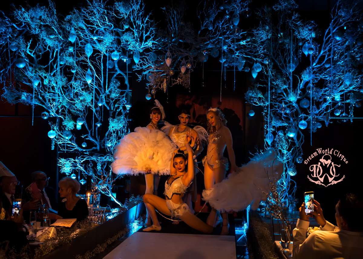 Four beautiful Performers create a beautiful shape at the end of the catwalk with a display of beautiful lights and trees around them